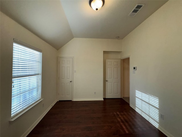 empty room with vaulted ceiling and dark hardwood / wood-style flooring