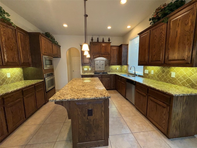 kitchen with sink, a center island, hanging light fixtures, light tile patterned floors, and appliances with stainless steel finishes