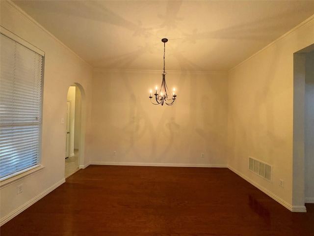 empty room featuring crown molding, dark hardwood / wood-style flooring, and an inviting chandelier