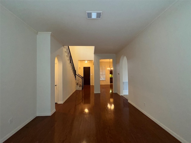 hallway with dark hardwood / wood-style flooring and ornamental molding