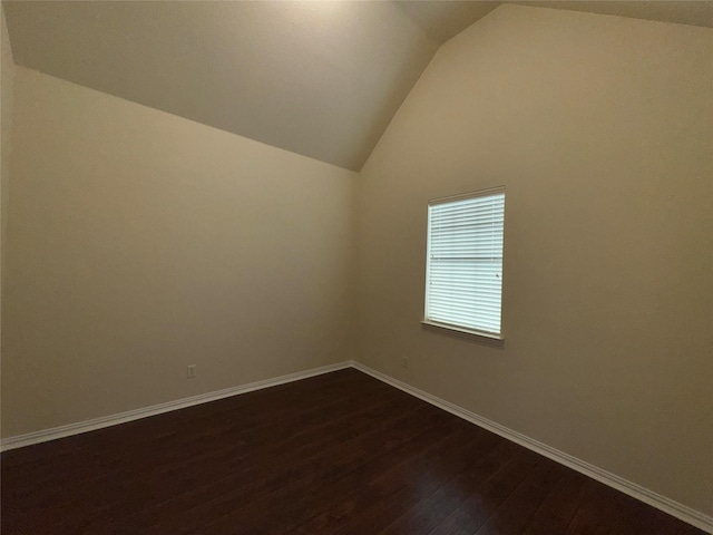 empty room with vaulted ceiling and hardwood / wood-style floors