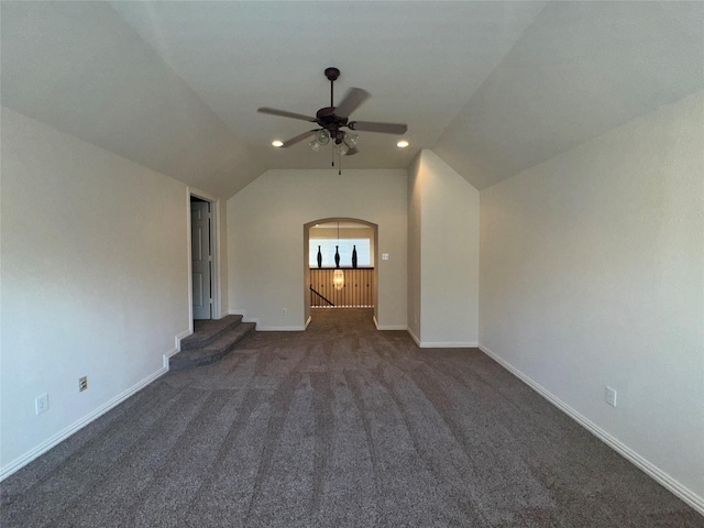 unfurnished living room with lofted ceiling, ceiling fan, and dark colored carpet