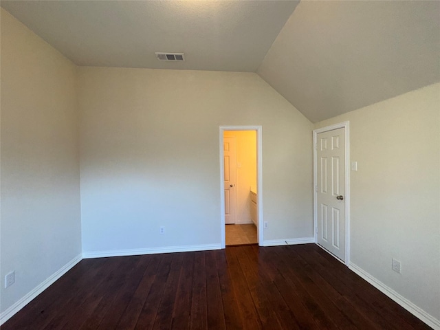 empty room featuring lofted ceiling and dark hardwood / wood-style floors