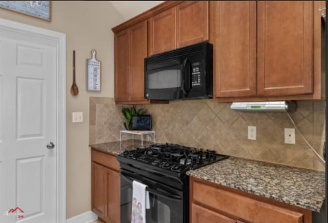 kitchen with light stone counters, backsplash, and black appliances