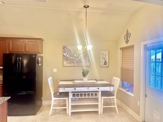 dining room featuring lofted ceiling, a chandelier, and light tile patterned floors