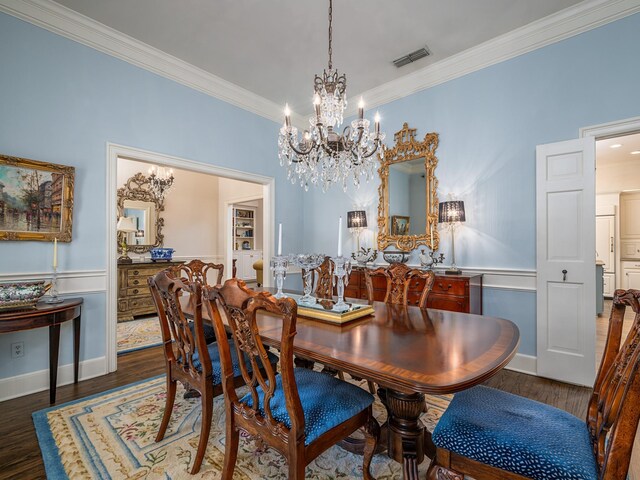 dining area featuring ornamental molding, dark wood-type flooring, and an inviting chandelier