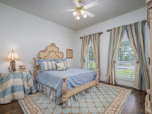 bedroom with crown molding, dark hardwood / wood-style floors, and ceiling fan