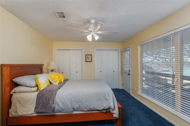 400 Driftwood Ct, Azle, TX 76020 - bedroom with dark colored carpet, multiple closets, a textured ceiling, and a ceiling fan