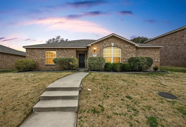 single story home featuring a lawn