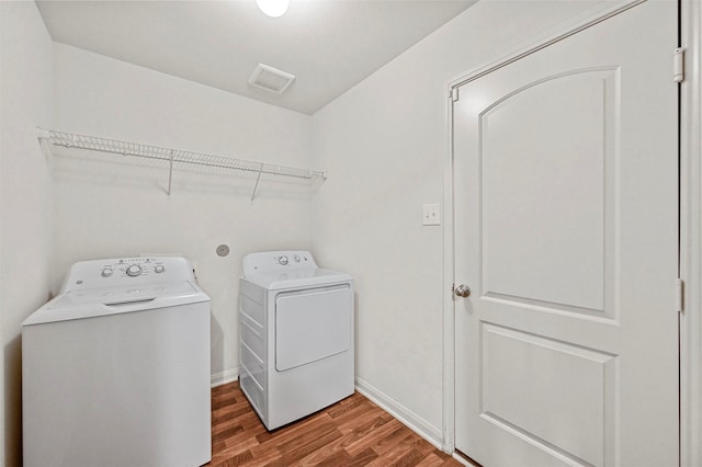 laundry room with hardwood / wood-style floors and washer and clothes dryer