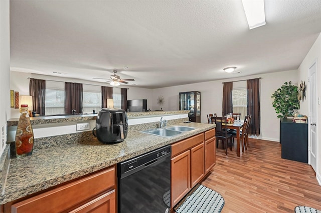 kitchen featuring dishwasher, sink, ceiling fan, light hardwood / wood-style floors, and a textured ceiling