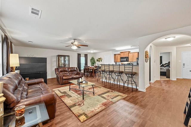 living room with hardwood / wood-style flooring and ceiling fan