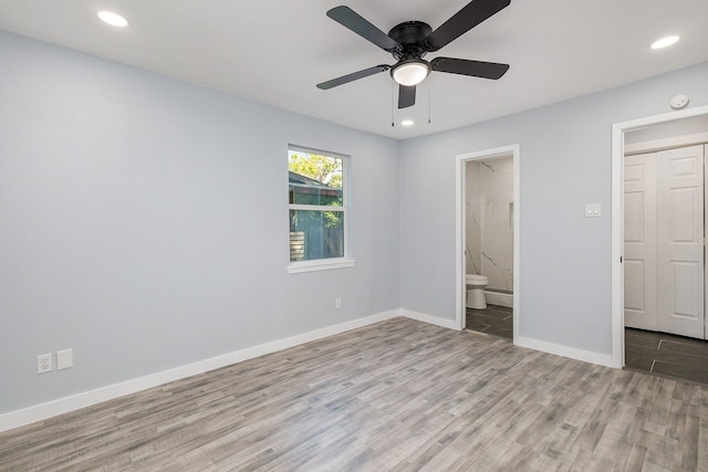 unfurnished bedroom featuring ceiling fan, ensuite bathroom, and light hardwood / wood-style floors