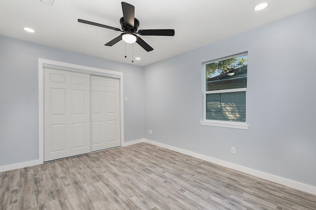 unfurnished bedroom featuring light hardwood / wood-style flooring, a closet, and ceiling fan