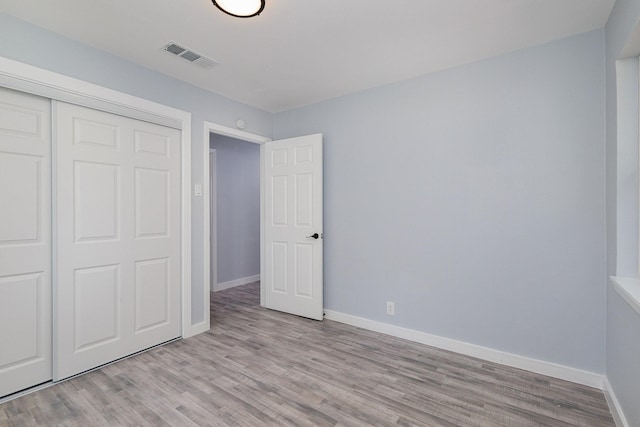 unfurnished bedroom with light hardwood / wood-style floors and a closet