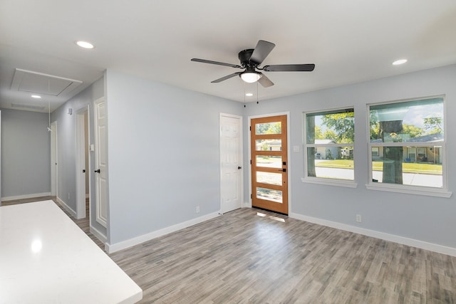 foyer entrance with ceiling fan and light hardwood / wood-style floors