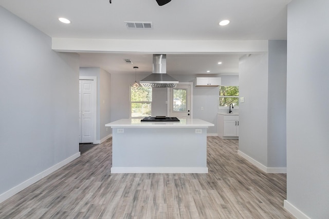 kitchen featuring extractor fan, decorative light fixtures, black gas cooktop, white cabinets, and a center island