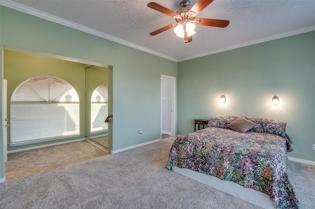 carpeted bedroom featuring ceiling fan, a textured ceiling, baseboards, and crown molding