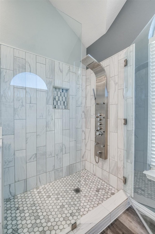 full bath featuring lofted ceiling and a stall shower