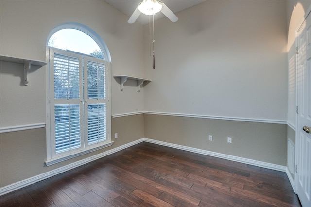 unfurnished room featuring dark wood-style flooring, a ceiling fan, and baseboards