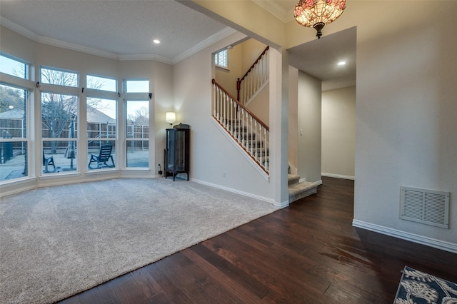 unfurnished living room featuring baseboards, visible vents, dark wood finished floors, stairway, and ornamental molding