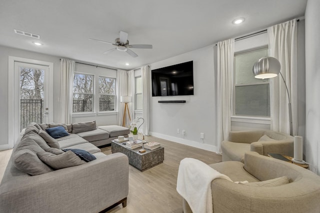 living room featuring ceiling fan and light wood-type flooring