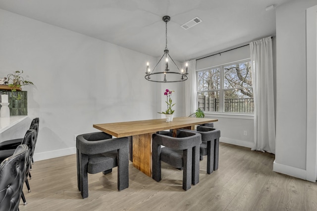 dining area with an inviting chandelier and light wood-type flooring