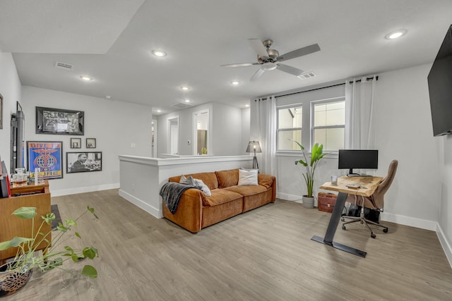 living room with light hardwood / wood-style flooring and ceiling fan