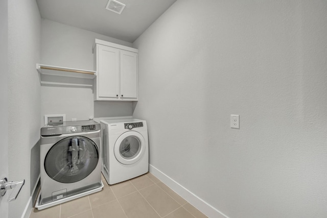 laundry room with cabinets, light tile patterned flooring, and independent washer and dryer