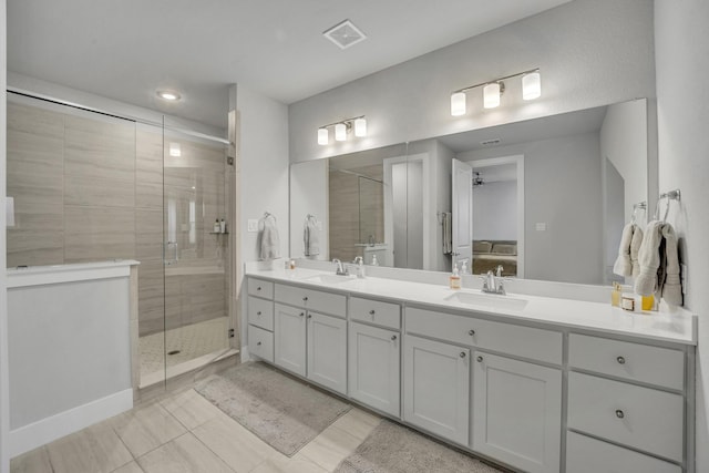 bathroom with vanity, a shower with shower door, and ceiling fan