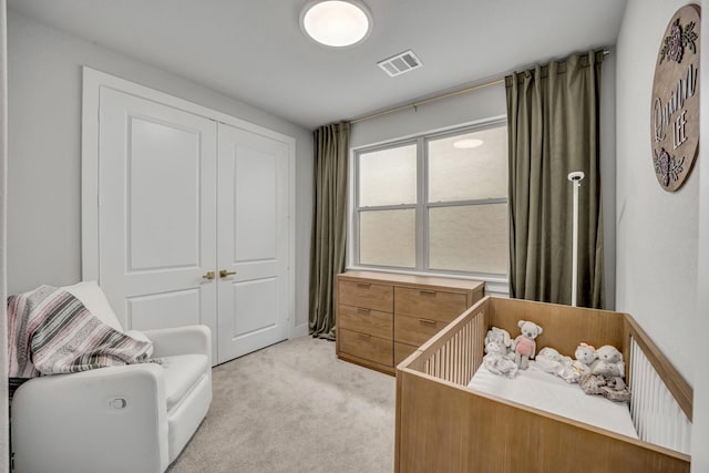 bedroom featuring light carpet and a closet