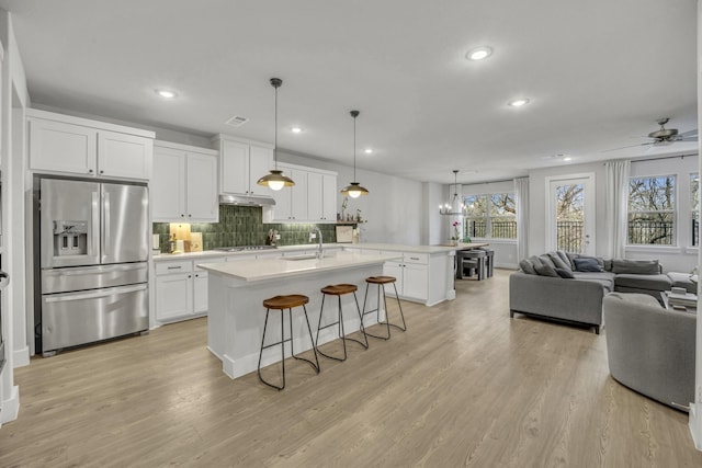 kitchen featuring an island with sink, white cabinets, and appliances with stainless steel finishes