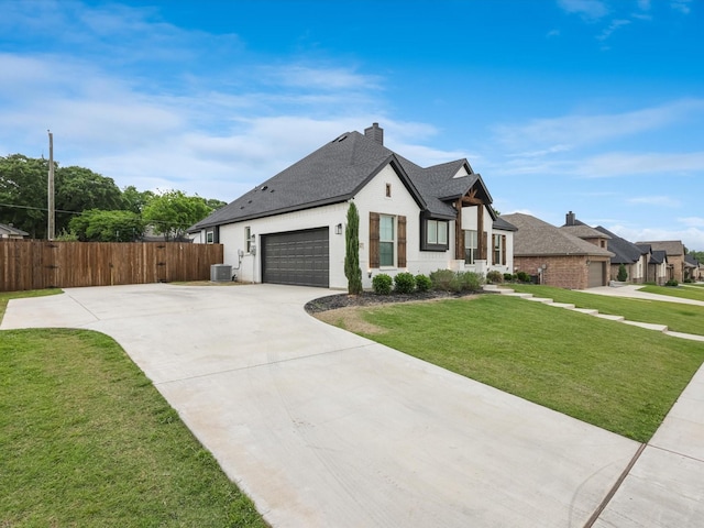 view of front of house with a garage, central AC, and a front yard