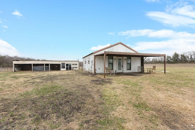 rear view of property featuring an outbuilding and a yard