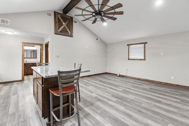 kitchen with a center island, high vaulted ceiling, ceiling fan, beam ceiling, and light hardwood / wood-style floors