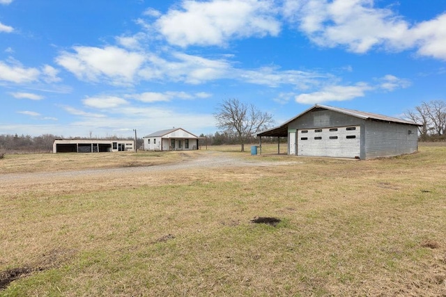 view of yard with a carport, a garage, and an outdoor structure