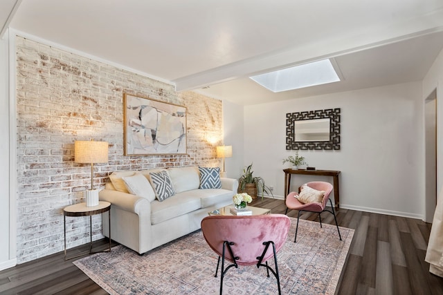 living room with brick wall, dark hardwood / wood-style flooring, a skylight, and beam ceiling
