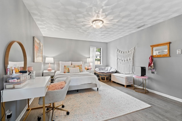 bedroom with hardwood / wood-style flooring and a textured ceiling