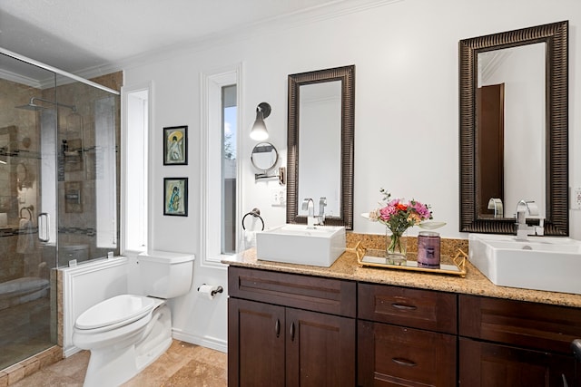 bathroom with vanity, crown molding, toilet, and walk in shower