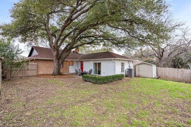 back of property featuring cooling unit, a lawn, and a shed