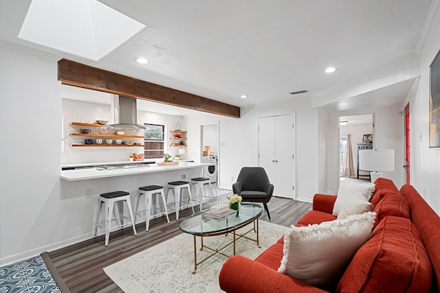 living room featuring washer / clothes dryer, crown molding, and dark wood-type flooring