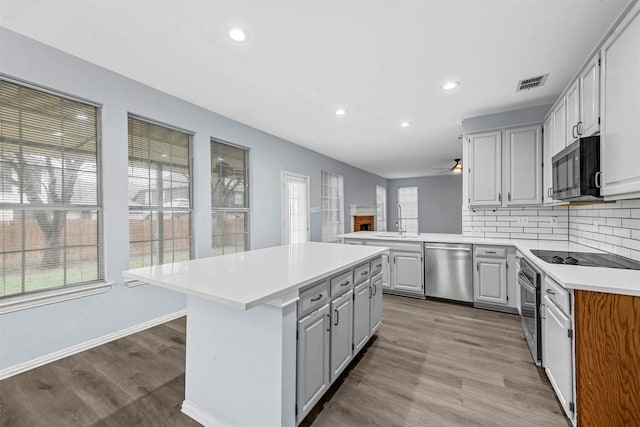 kitchen with tasteful backsplash, sink, a center island, stainless steel dishwasher, and kitchen peninsula