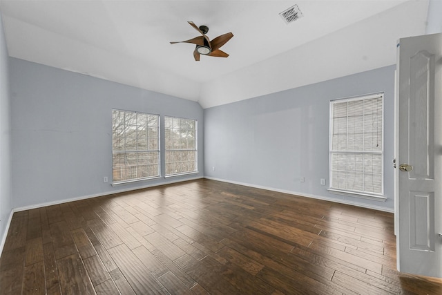 empty room with dark hardwood / wood-style flooring, vaulted ceiling, and ceiling fan