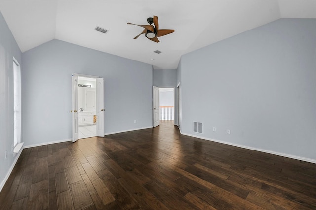 interior space with lofted ceiling, dark hardwood / wood-style floors, connected bathroom, and ceiling fan