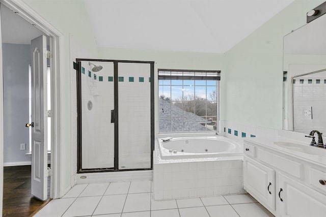 bathroom with tile patterned floors, lofted ceiling, plus walk in shower, and vanity