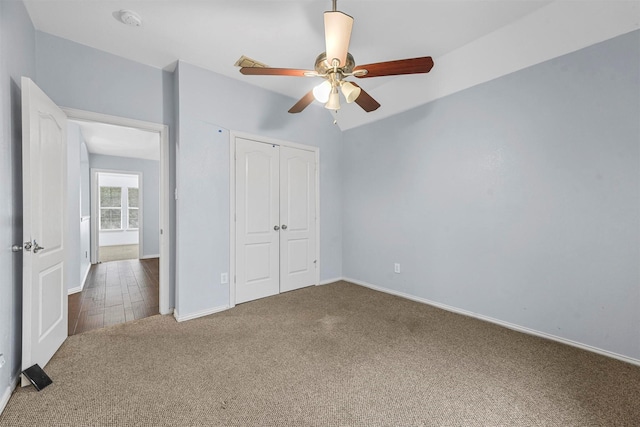 unfurnished bedroom featuring carpet, ceiling fan, and a closet