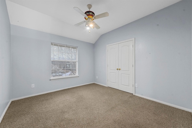 unfurnished bedroom featuring ceiling fan, lofted ceiling, carpet floors, and a closet