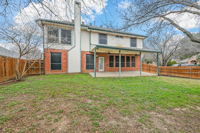 rear view of property featuring a lawn and a patio area