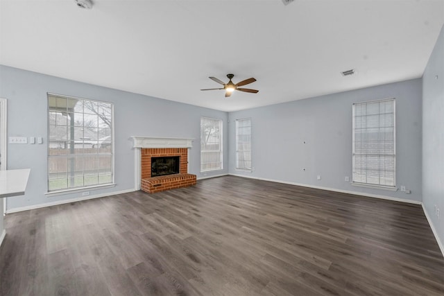 unfurnished living room featuring dark wood-type flooring, a fireplace, and ceiling fan