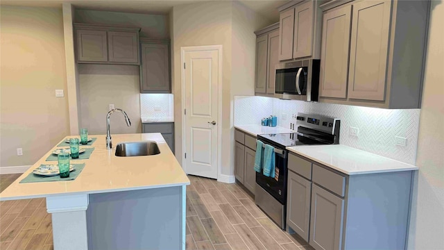 1749 River Bend Rd, Burleson, TX 76028 - kitchen featuring appliances with stainless steel finishes, a sink, gray cabinetry, and light wood-style flooring